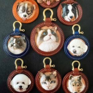 Nine Custom Pet Portrait Keychains, each featuring a detailed engraved 3D animal face of various cats and dogs on a personalized leather base. These unique Christmas presents for pet lovers showcase circular designs with brass-colored hooks, set against a dark background.