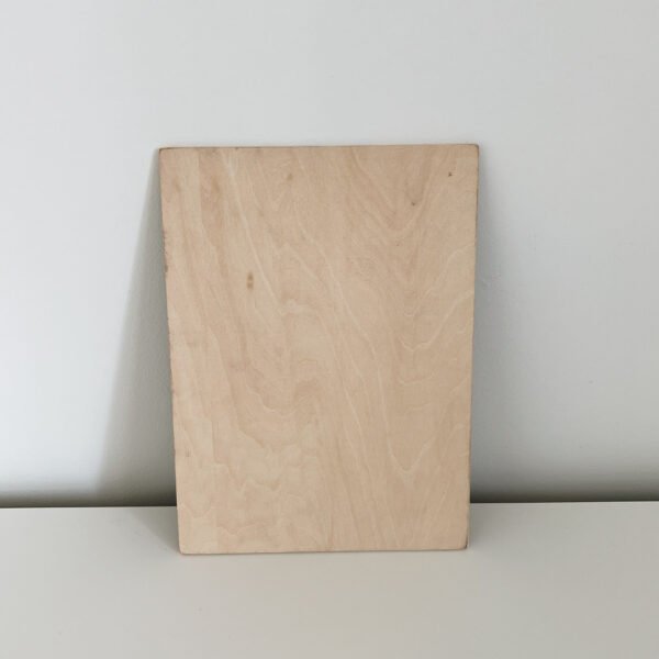 A Custom Wooden Engraved Pet Portrait – Handmade, Eco-Friendly Memorial Gift, crafted from a rectangular piece of light-colored wood with a smooth surface, is artfully displayed leaning against a plain white wall on a light-colored surface, showcasing exquisite engraved details.